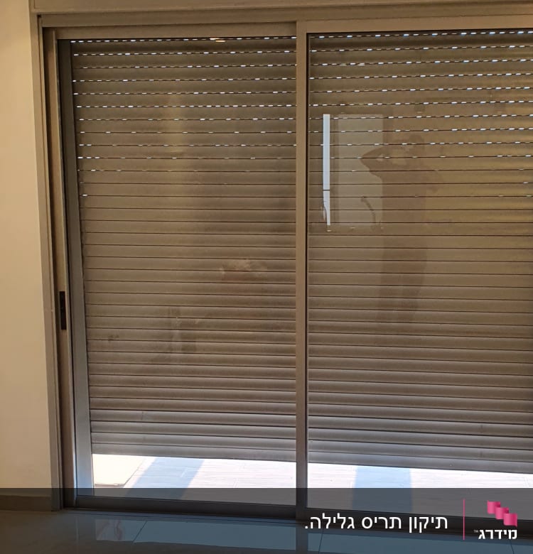 תריסים סגורים על חלון זכוכית גדול